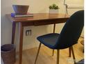 Home office area with a wood desk, modern chair, books, potted plants, and neutral walls at 1111 Maxwell Ave # 109, Boulder, CO 80304