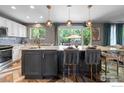 Modern kitchen featuring white cabinets, quartz countertops, stainless steel appliances, and an eat-in island at 1500 Red Mountain Dr, Longmont, CO 80504