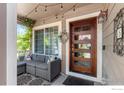 Inviting covered front porch with outdoor seating, decorative touches, and a welcoming entrance at 1500 Red Mountain Dr, Longmont, CO 80504