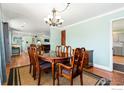 Elegant dining room with a chandelier, wooden table with chairs, and an open layout at 16160 Yosemite St, Brighton, CO 80602