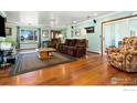 Bright living room with hardwood floors, ample seating, and natural light from large windows at 16160 Yosemite St, Brighton, CO 80602