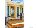 Close-up of the front door with sidelights and wood porch with planters at 2017 Vaquero St, Longmont, CO 80504