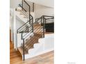 Modern staircase with wooden treads and sleek black metal railings at 2017 Vaquero St, Longmont, CO 80504