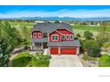 Aerial view of a two-story red home with a well-kept lawn and mountain views at 2290 Cottonwood Pl, Erie, CO 80516