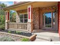 Inviting front porch with stone accents, leading to a glass front door with sidelights at 2290 Cottonwood Pl, Erie, CO 80516