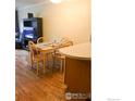 Bright dining area adjacent to the kitchen with wooden table, chairs and hardwood floors at 2295 E Asbury Ave # 206, Denver, CO 80210