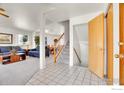 Bright and airy living room with white walls, light carpet, and staircase at 2410 Key Ct, Longmont, CO 80501