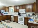 The kitchen features wooden cabinets, white appliances, and ample countertop space at 2434 S Kirkwood Ct, Denver, CO 80222