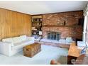 The living room features a brick fireplace with built-in shelves and bright natural lighting at 2434 S Kirkwood Ct, Denver, CO 80222