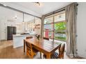Cozy dining area adjacent to the kitchen, with a rustic wooden table and an industrial glass garage door at 2602 Tumwater Ln, Boulder, CO 80304