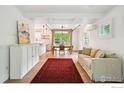 Airy living room with hardwood floors, white walls, and a large glass garage door providing ample natural light at 2602 Tumwater Ln, Boulder, CO 80304