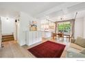 Bright living room featuring hardwood floors, a large red rug, and an industrial-style glass garage door at 2602 Tumwater Ln, Boulder, CO 80304
