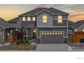 Twilight view of two-story home with a gray exterior, large two-car garage, and a well-maintained front yard at 270 Sabin Way, Lochbuie, CO 80603