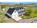 Aerial view of a charming home with a large front porch on a spacious lot near a lake and rolling hills at 5306 Foothills Dr, Berthoud, CO 80513