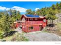 Rustic two story home featuring a solar panel, and well-maintained landscaping on a sunny day at 548 Coughlin Meadows Rd, Boulder, CO 80302