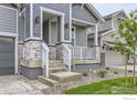 Charming covered porch with stone details and steps leading to the front door enhances the home's appeal at 5891 Aspenglow St, Longmont, CO 80504