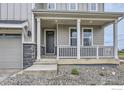 Inviting front porch with white railings and stone accents on a charming home at 5901 Aspenglow St, Longmont, CO 80504