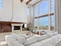 A spacious living room with a stone fireplace, cathedral ceilings, large windows, and comfortable seating at 6541 Legend Ridge Trl, Niwot, CO 80503