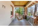 Inviting front porch featuring stone pillars, wood ceiling, and a relaxing porch swing at 721 9Th St, Boulder, CO 80302