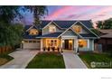 A stunning exterior view showing the home's architectural style, garage, manicured lawn, and welcoming front porch at 724 Johnson St, Louisville, CO 80027