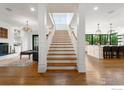 Bright, open entry featuring wood stairs, wood floors, and views into the kitchen and living areas at 724 Johnson St, Louisville, CO 80027