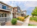 View of new townhome construction with gray siding, stone accents, and landscaping at 749 Robert St, Longmont, CO 80503