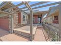 Inviting covered front patio and entrance featuring stone accents and pleasant outdoor space at 1130 Summit View Dr, Louisville, CO 80027