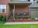 Welcoming front porch with seating area and decorative details on a brick-front home at 1141 Jefferson Dr, Berthoud, CO 80513