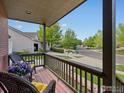 Cozy front porch view with wicker seating and colorful potted flowers overlooking the street at 1141 Jefferson Dr, Berthoud, CO 80513