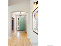 Bright entryway features hardwood floors, arched doorways, and a stylish light fixture at 123 Ortega Ct, Erie, CO 80516