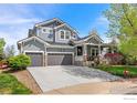 Charming two-story home with a covered porch, gray siding, and a two-car garage at 123 Ortega Ct, Erie, CO 80516