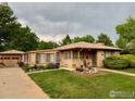 Charming single-story home with a well-manicured lawn and detached garage at 1235 Lincoln St, Longmont, CO 80501