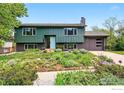 Unique two-story home with a green exterior, blue door, and beautifully landscaped front yard at 1350 Lehigh St, Boulder, CO 80305