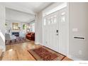 Bright foyer with hardwood floors, a large front door, and views into the living room with fireplace at 1380 Bluebell Ave, Boulder, CO 80302