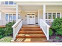 Inviting front porch with wooden stairs, white railings, and a covered entrance, perfect for relaxing outdoors at 1380 Bluebell Ave, Boulder, CO 80302
