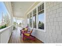 Cozy side porch with wooden floors, white railings, and chairs offering a relaxing outdoor space at 1380 Bluebell Ave, Boulder, CO 80302