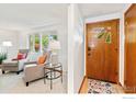 Inviting entryway featuring a decorative wood door and light-filled living room with comfortable seating at 1429 Linden St, Longmont, CO 80501