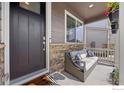 Inviting front porch with a comfortable seating area and decorative plants for a relaxing outdoor space at 14640 Guernsey Dr, Mead, CO 80542