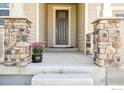 Inviting front porch with decorative stone pillars and a charming potted plant at 1471 Sabin Ct, Berthoud, CO 80513