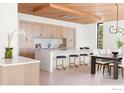 Modern kitchen with a large island, stool seating, wooden ceiling, adjacent to dining area at 1575 Linden Dr, Boulder, CO 80304