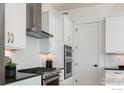 Close-up of modern kitchen details with white cabinets, stainless steel appliances, and stylish backsplash at 1611 Poplar Dr, Erie, CO 80516