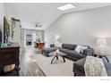 Sun-filled living room boasts vaulted ceilings, skylights, a modern sofa, and hardwood floors at 1695 Parkside Cir, Lafayette, CO 80026