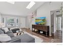 Bright and inviting living room featuring skylights, a stylish sectional, and wood laminate flooring at 1695 Parkside Cir, Lafayette, CO 80026