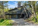 Picturesque two-story home with black exterior and decks nestled among trees at 1750 Deer Trail Rd, Boulder, CO 80302