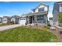 Charming two-story home with stone accents, a covered porch, landscaped yard, and an attached two-car garage at 1923 High Plains Dr, Longmont, CO 80503