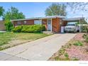 Charming single-story brick home with carport and tidy landscaping along driveway and front perimeter at 245 S 13Th Ave, Brighton, CO 80601