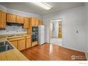 Eat-in kitchen with wood cabinets, stainless steel appliances, and hardwood floors at 245 S 13Th Ave, Brighton, CO 80601