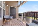 Relaxing balcony with comfortable seating, a barbecue grill, and views of the community parking area at 3095 Blue Sky Cir # 305, Erie, CO 80516