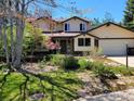 Charming two-story home featuring a well-manicured front yard with beautiful landscaping and mature trees at 4311 Pali Way, Boulder, CO 80301