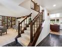 A carpeted staircase with dark wooden banister, adjacent to the living room and kitchen areas at 4311 Pali Way, Boulder, CO 80301